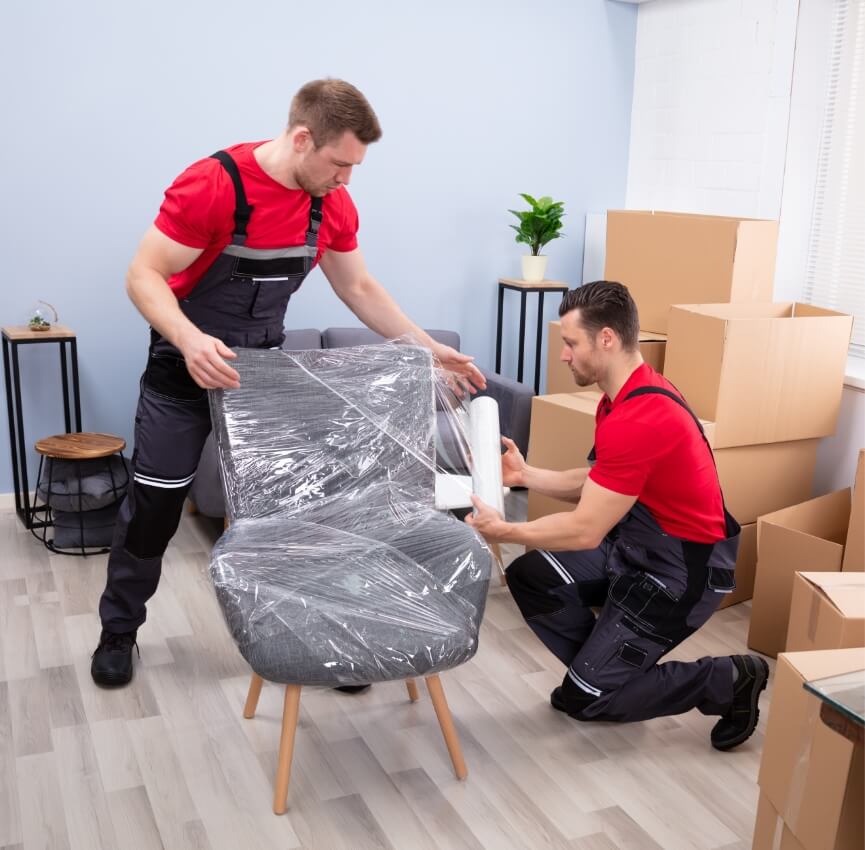 Zwei Umzugshelfer bereiten einen Stuhl für den Umzug vor